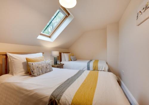 two beds in a attic bedroom with a window at Cil y Fan in Llangelynin