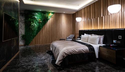 a hotel room with a bed and a painting on the wall at Aquarius Motel in Taichung