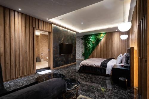 a hotel room with a bed and a tv at Aquarius Motel in Taichung