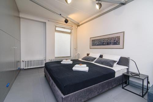1 dormitorio con 1 cama grande y 2 toallas. en Hidden Submarine, en Vilna