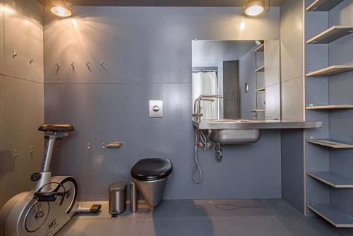 y baño con lavabo, aseo y espejo. en Hidden Submarine, en Vilna