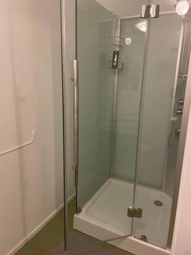 a shower with a glass door in a bathroom at Hotell Silverborgen in Sala