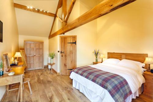 a bedroom with a large bed and a wooden floor at Woodlands Farm in Osmotherley