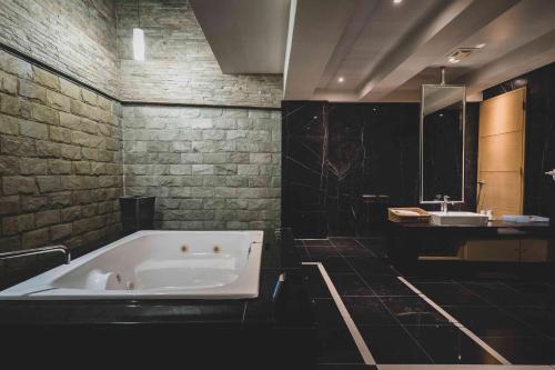 a bathroom with a large bath tub and a sink at Aquarius Motel in Taichung