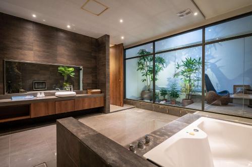 a bathroom with a tub and a large window at Aquarius Motel in Taichung