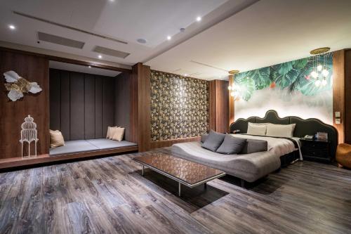 a bedroom with a bed and a couch and a table at Aquarius Motel in Taichung