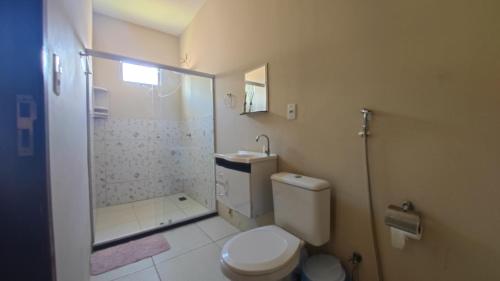 a bathroom with a white toilet and a shower at Casa Laguna - Barra Jacuípe in Camaçari