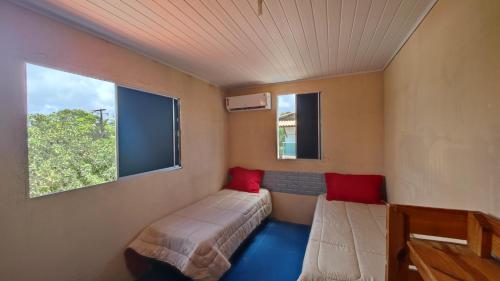 a small room with two beds and a window at Casa Laguna - Barra Jacuípe in Camaçari