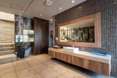 a bathroom with a sink and a large mirror at Aquarius Motel in Taichung