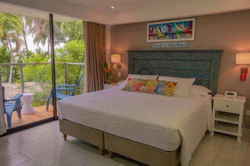 a bedroom with a large bed and a large window at Casa Verano Beach Hotel - Adults Only in Santa Marta