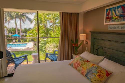a bedroom with a bed and a view of a pool at Casa Verano Beach Hotel - Adults Only in Santa Marta