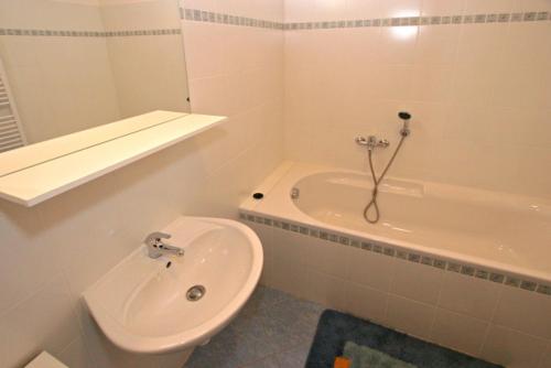 uma casa de banho com um lavatório, uma banheira e um WC. em Apartmány Doky Holiday em Lipno nad Vltavou