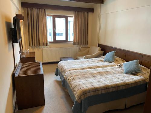 Una habitación de hotel con dos camas y un televisor. en Beceren Hotel, en Bursa
