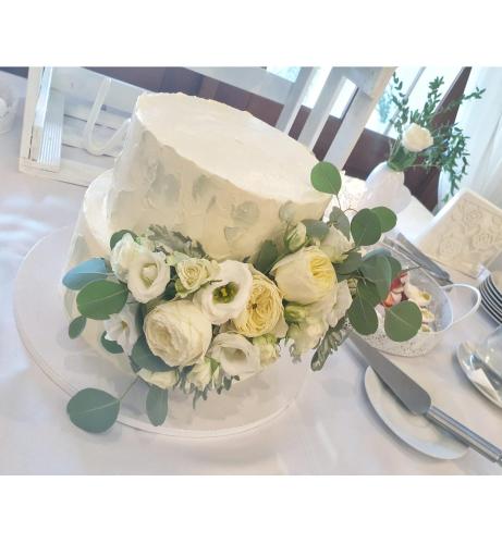 a white cake with flowers on a table at ROMANTIK HOTEL ELEONORA in Tábor
