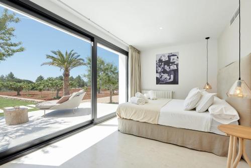 a bedroom with a bed and a large window at Exquisite Ibiza Villa Can Pegaso Grande Privileged Minimalist Style 16 guests San Juan in Sant Joan de Labritja