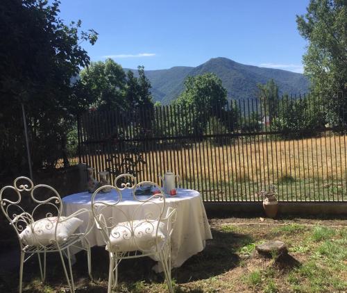 a table and chairs with a table and a fence at La Furmumecha VUT-LE-611 Apartamento in Villablino