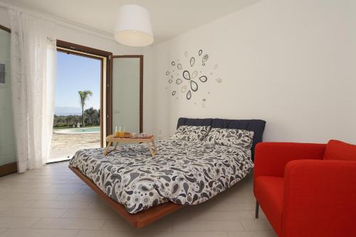 1 dormitorio con 1 cama y 1 sofá rojo en Villa delle Stelle en Scopello