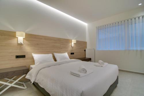 a bedroom with a large white bed with towels on it at ''Γειτονιά της γνώσης'' Luxury Apartments Ioannina in Ioannina