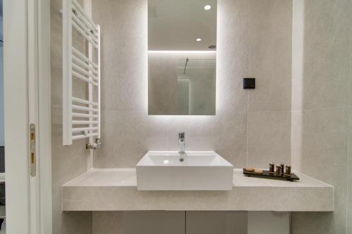 a bathroom with a white sink and a mirror at ''Γειτονιά της γνώσης'' Luxury Apartments Ioannina in Ioannina