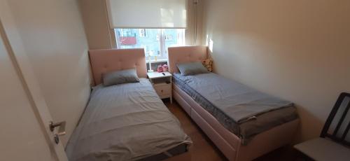 2 łóżka w małym pokoju z oknem w obiekcie Sääse 3 Apartment w Tallinnie