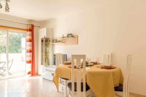 ein Esszimmer mit einem Tisch und einem gelben Tischtuch in der Unterkunft Albufeira Old Town Two bedroom Apartment Center in Albufeira