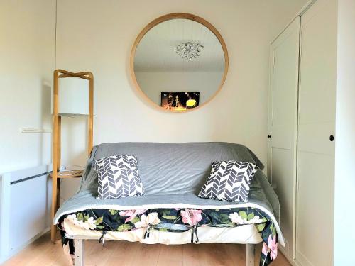 - une chambre avec un lit et un miroir mural dans l'établissement Diamant Studio classé 3 Étoiles, à Saint-Germain-en-Laye