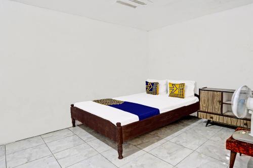- une chambre avec un lit et un mur blanc dans l'établissement OYO 91865 Sidomulyo Kost Syariah, à Mojokerto
