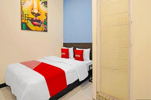 a bedroom with two beds with red pillows at OYO 91867 Gangnam Style Kutai in Surabaya