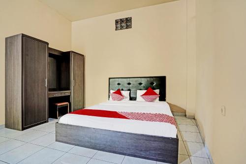 1 dormitorio con 1 cama grande con almohadas rojas en OYO Life 91873 Nugraha Kost, en Palembang