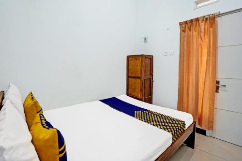 - une chambre avec un lit blanc et une fenêtre dans l'établissement OYO Life 91866 Paradise Ok Kost Syariah, à Mojokerto