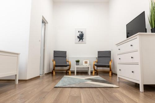 a living room with two chairs and a dresser at Zakarias Apartments in Miercurea-Ciuc