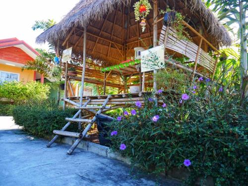 Ban Nong Tum的住宿－อวบอิ๋มรีสอร์ท #ที่พักภูกระดึง，长凳和茅草屋顶的房子