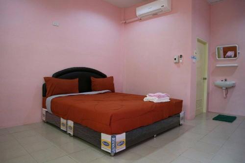 Ban Nong Tum的住宿－อวบอิ๋มรีสอร์ท #ที่พักภูกระดึง，粉红色客房内的一间卧室,配有一张床