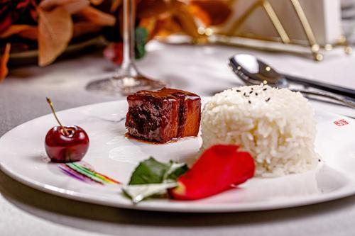 a white plate with a piece of cake and rice at LDS Hotel Belgrade in Belgrade
