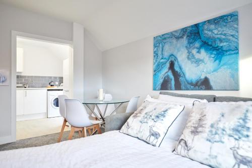 a white bedroom with a bed and a table at homely - Great Yarmouth Beach Apartments in Great Yarmouth