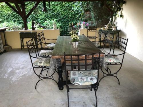 une table avec quatre chaises et une table avec des fleurs. dans l'établissement au café de la gare, SPA, Pêche en Saone Bourgogne Maison de charme spacieuse Dijon Dole Gray, à Pontailler-sur-Saône