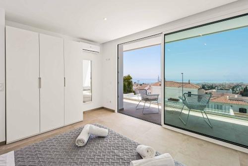 Cette grande chambre blanche dispose d'une grande fenêtre en verre. dans l'établissement Villa Felix Uno, à Nerja