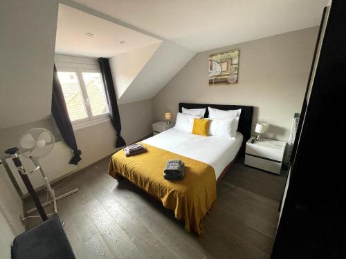 a bedroom with a large bed with a yellow blanket at Le 3 de Coeur Annecy in Annecy