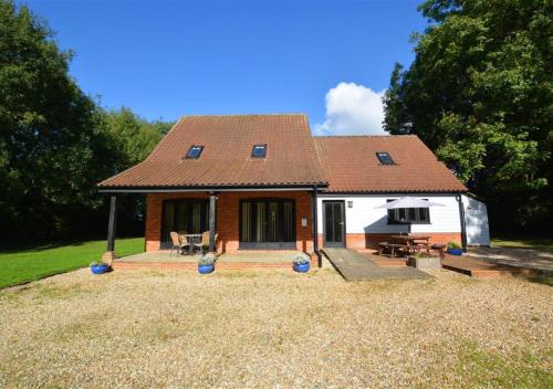 a small house with a roof on a yard at Shuttleworth Lodge in Thursford