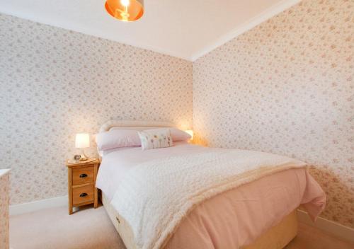 a bedroom with a bed and a table with a lamp at Seascape in Walmer