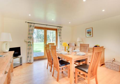 a dining room with a wooden table and chairs at Shuttleworth Lodge in Thursford