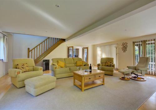a large living room with couches and a table at Shuttleworth Lodge in Thursford