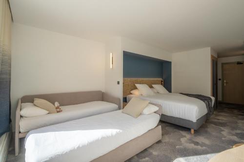 a hotel room with two beds and a couch at La Cachette, Friendly Hotel & Spa in Arc 1600