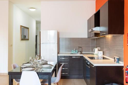 a kitchen with a table with chairs and a refrigerator at Lovely, Spacious High Floor APT in central PV & AC by 360 Estates in Paceville