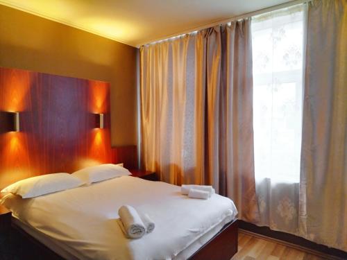 Milky Way Hotel في بودابست: غرفة نوم بسرير كبير مع نافذة