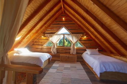 a bedroom with two beds in a log cabin at Encantadora Casa del Árbol en el Valle del Elqui! in La Serena