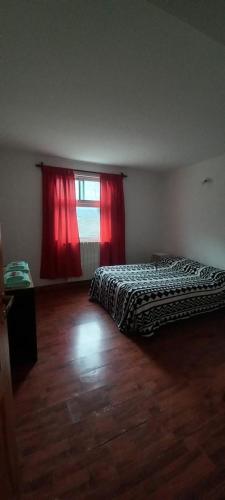 Azul في أوشوايا: غرفة نوم بسريرين ونافذة ذات ستائر حمراء