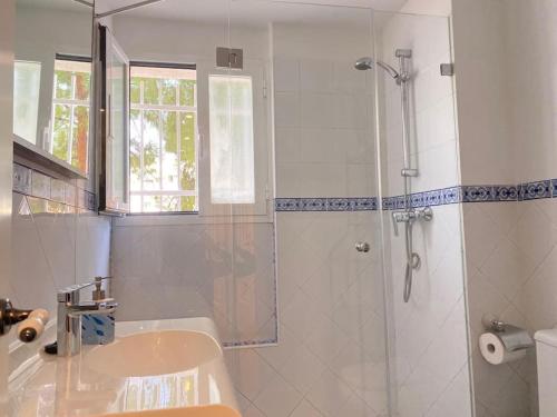 biała łazienka z prysznicem i umywalką w obiekcie Hispalis Nervión w Sewilli