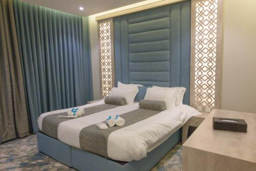 a bedroom with a large bed with two towels at شقق واي سويت للشقق المخدومة in Abha