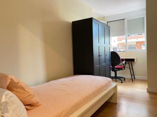 1 dormitorio con armario negro y escritorio en Hispalis Nervión, en Sevilla